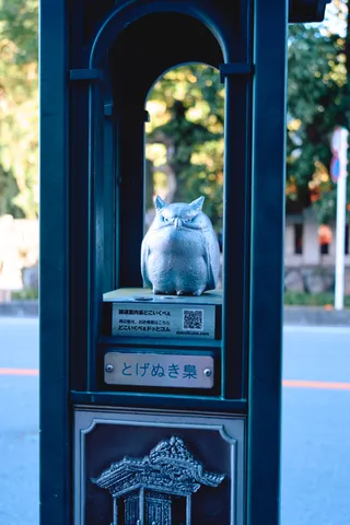 鉄の柱のアーチの中に置かれた、ふくろうの像