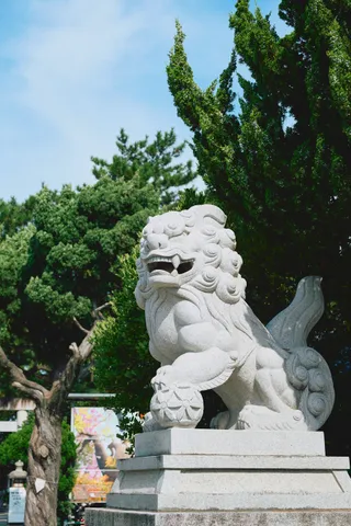 木立を背にした、神社の石造りの狛犬