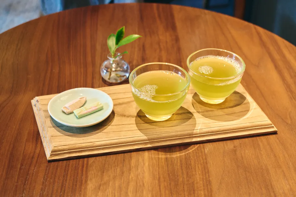 木の盆にのった2杯の冷たい緑茶と和菓子