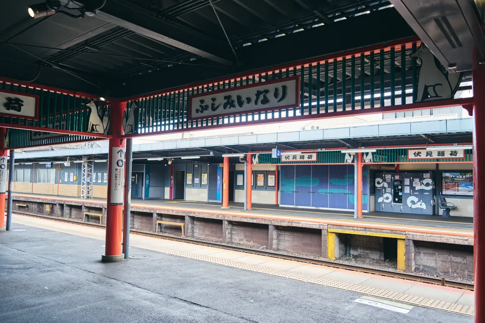 朱色の柱が並ぶ、ひと気のない駅のホーム