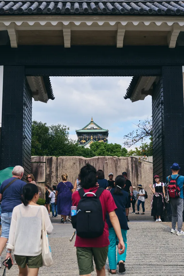 城門の枠の中に小さく見える天守と、門へ向かう人たち