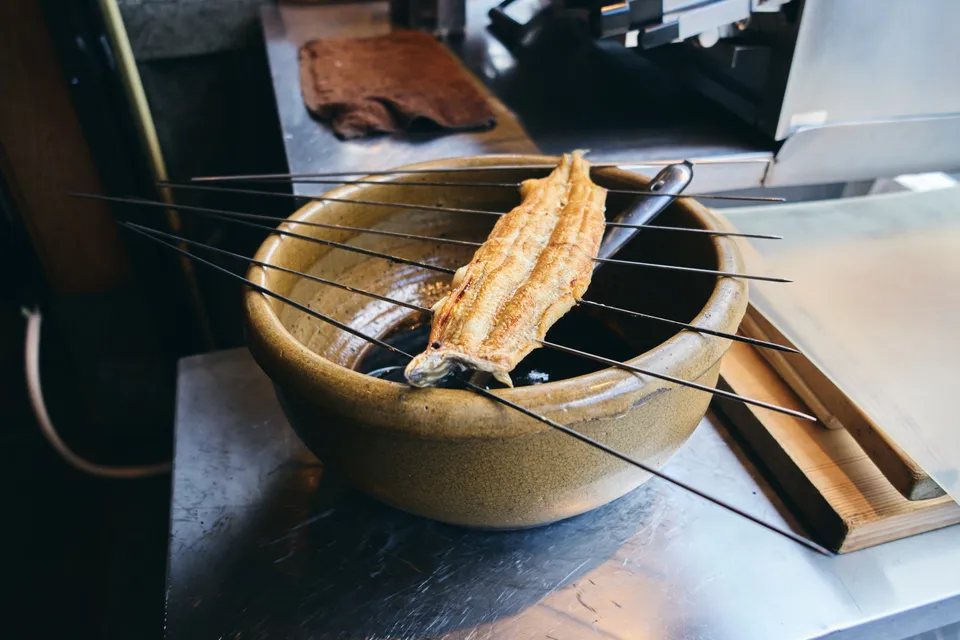 鉢に串ごと立てかけられた、焼いた鰻
